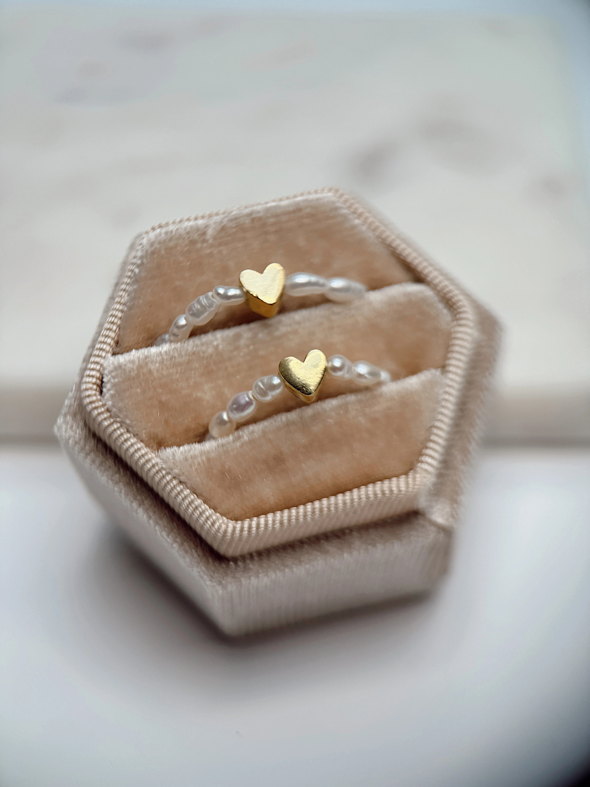 Handmade stretch ring with natural freshwater pearls and a gold-plated heart spacer