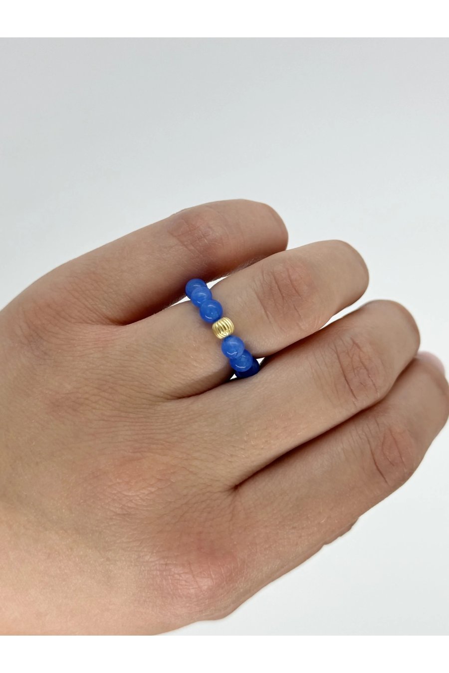 Elastische ring van blauwe jade met bolletje van verguld 925 zilver, geregen aan draad van 0,4 mm, handgemaakt