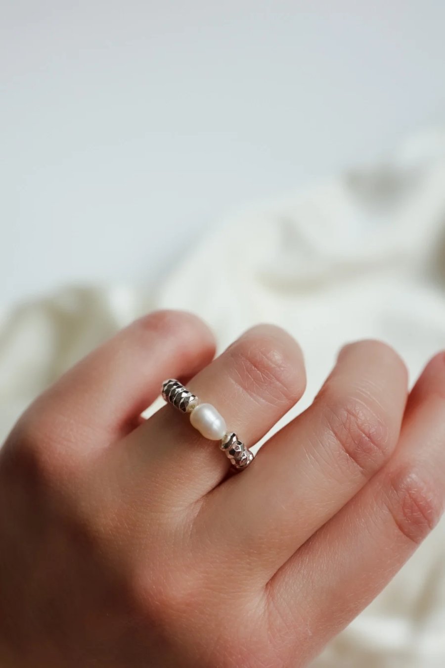 Elastische ring van zilverkleurige hematiet met een gekweekte zoetwaterparel aan elastisch draad, handgemaakt