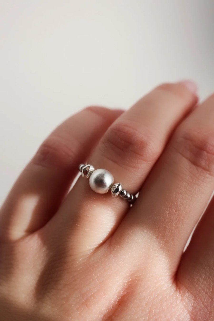 Elastische ring van hematiet in twee tinten zilver, geregen aan elastiekdraad, handgemaakt