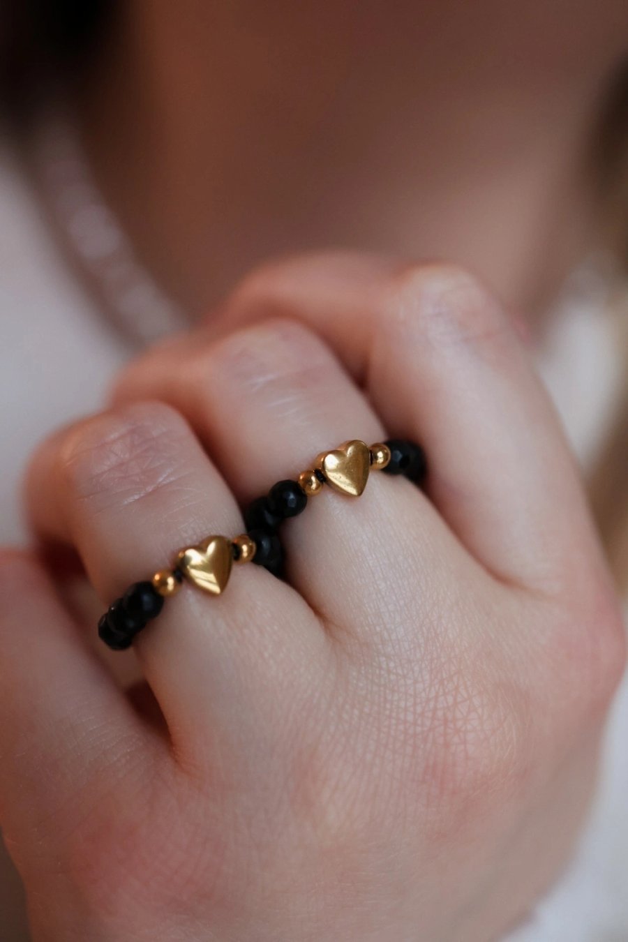 Stretch ring of matte black onyx with a gold hematite heart on elastic cord, handmade