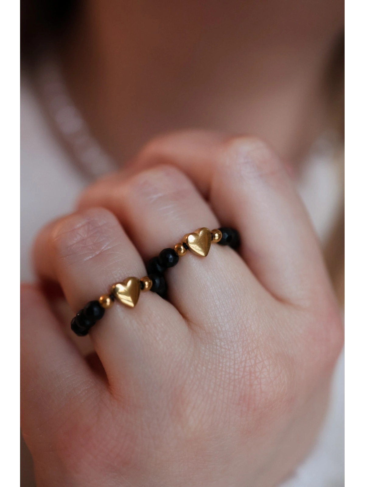 Elastische ring van mat zwart onyx met een goudkleurig hart van hematiet aan elastisch draad, handgemaakt