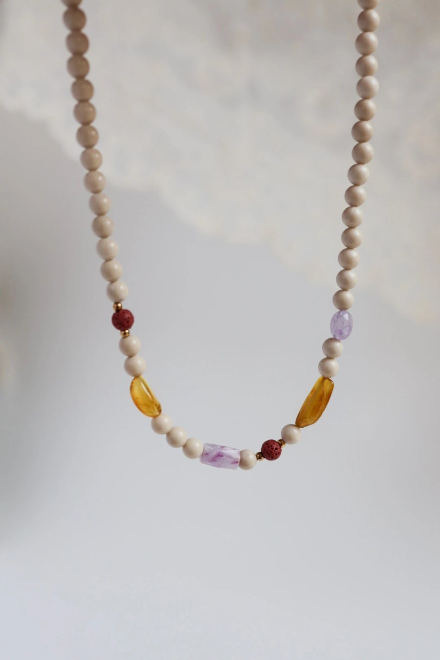 Handmade necklace of beige river stones with lava stone, amber, amethyst and kunzite