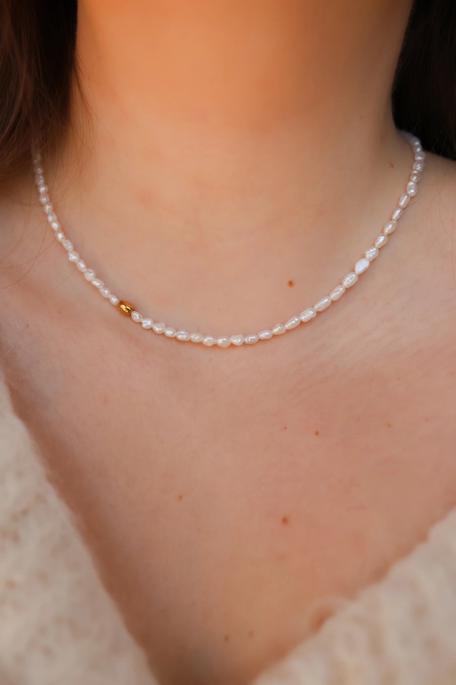 Fijne, subtiele ketting van piepkleine parels met een tussenstuk van goudkleurig hematiet, handmade